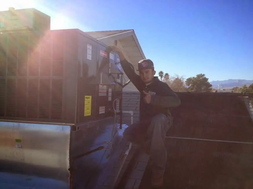 HVAC technician performing Boiler Repair on a rooftop unit in Fairmont
